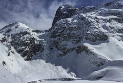 Descripción: Un hombre está esquiando por una montaña cubierta de nieve.