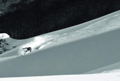Una persona esquiando por una pendiente cubierta de nieve con botas SCARPA.