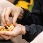 Una mujer sostiene en sus manos un puñado de nueces, una comida y un alimento.
